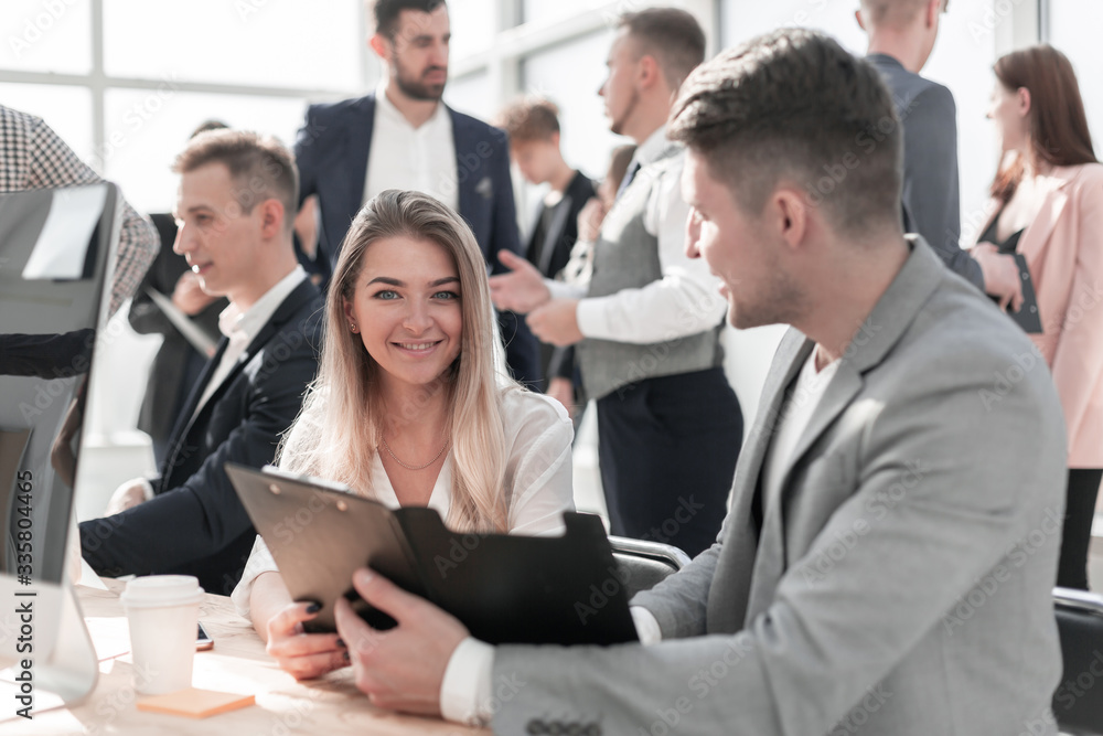 employees discussing business document sitting at office Desk employees discussing business document sitting at office Desk