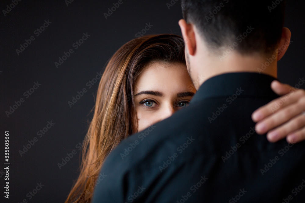 Love and care concept. Beautiful brunette woman with bright eyes looks on her boyfriend. Couple embrace. Love and care concept. Beautiful brunette woman with bright eyes looks on her boyfriend. Couple embrace.