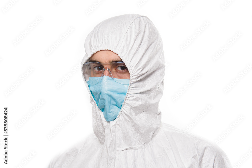 Portrait of young man in protective white medical uniform during coronavirus pandemic. Epidemic, pandemic of coronavirus covid 19. Portrait of young man in protective white medical uniform during coronavirus pandemic. Epidemic, pandemic of coronavirus covid 19.