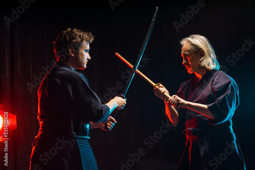 Fight between two caucasian kendo fighters, trainer and pupil sparring on training action. self defense, art exercise concept. traditional warriors skills, samurai