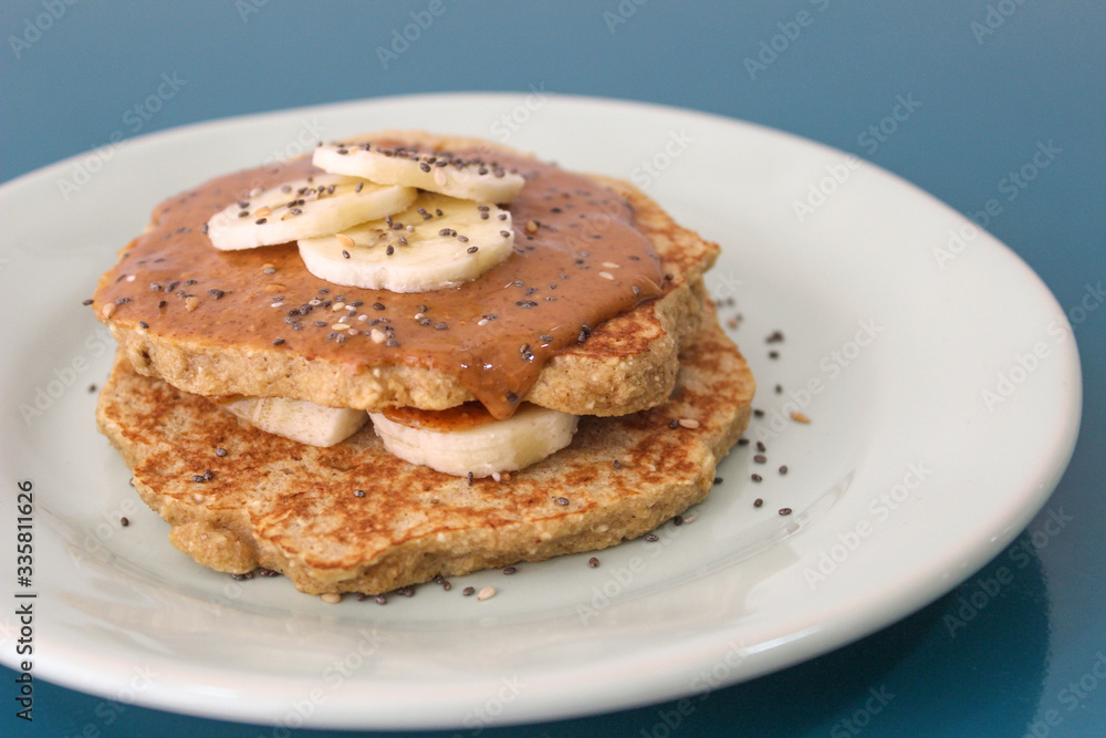 Oat pancakes with peanut butter and banana on a blue plate