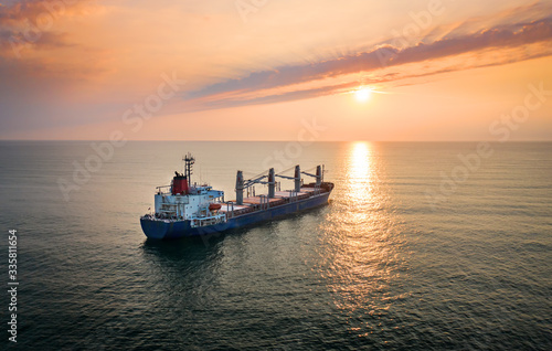 Cargo ship in the ocean on the sunrise.