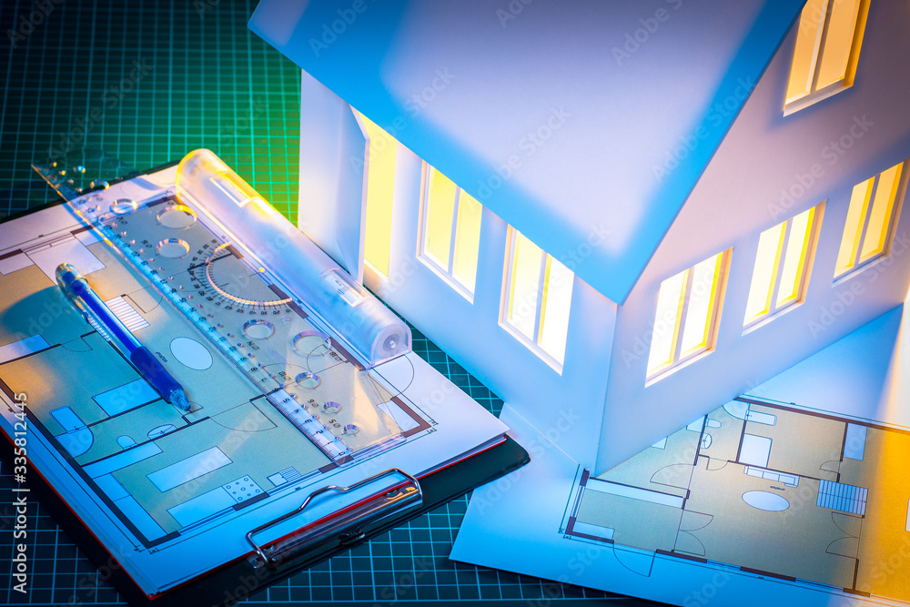Fototapeta premium Architectural Bureau. Construction drawings. Layout of the house. Preparation of the layout of the house. Miniature mock up house. Work in an architectural bureau. Development of drawings.