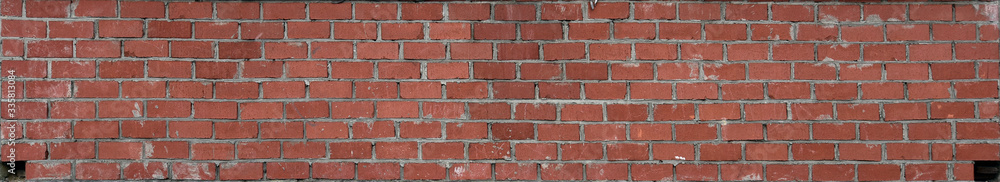 Obraz premium The brickwork of the old wall, uneven bricks and protruding mortar, sometimes destroyed.