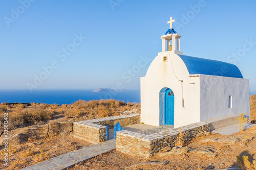 A beautiful old traditional chapel in Serifos island Greece by the sea against the deep blue sky during sunset in warm light