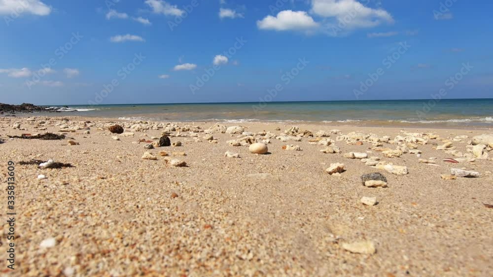 View from below of beautiful white sand Phra Ae long beach Koh Lanta island, Krabi, Thailand. Small waves splattering and splashing on rocky coast of sandy beach. Sunny day with clouds in sky. Full HD View from below of beautiful white sand Phra Ae long beach Koh Lanta island, Krabi, Thailand. Small waves splattering and splashing on rocky coast of sandy beach. Sunny day with clouds in sky. Full HD