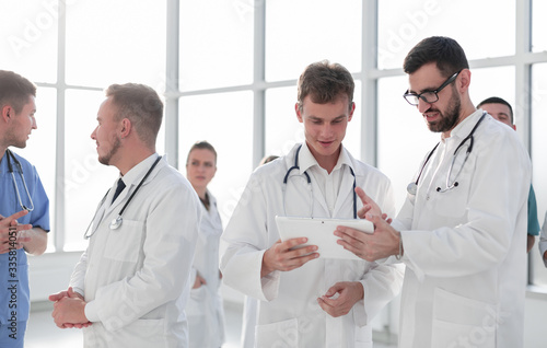 medical professionals looking at the screen of a digital tablet