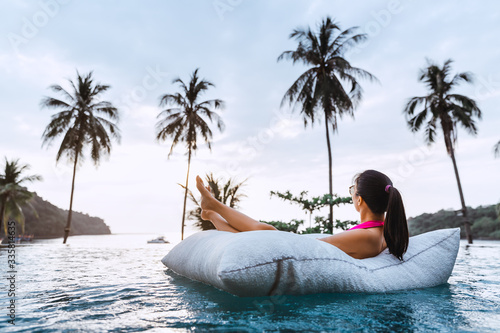 Asian woman relax in pool on beach © Peera