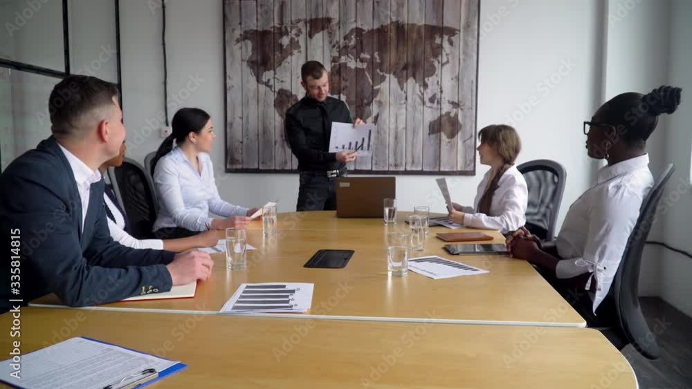 Business coach gives corporate presentation for businesspeople in office, dark skinned businessman presents new business plan, speaking to clients Business coach gives corporate presentation for businesspeople in office, dark skinned businessman presents new business plan, speaking to clients
