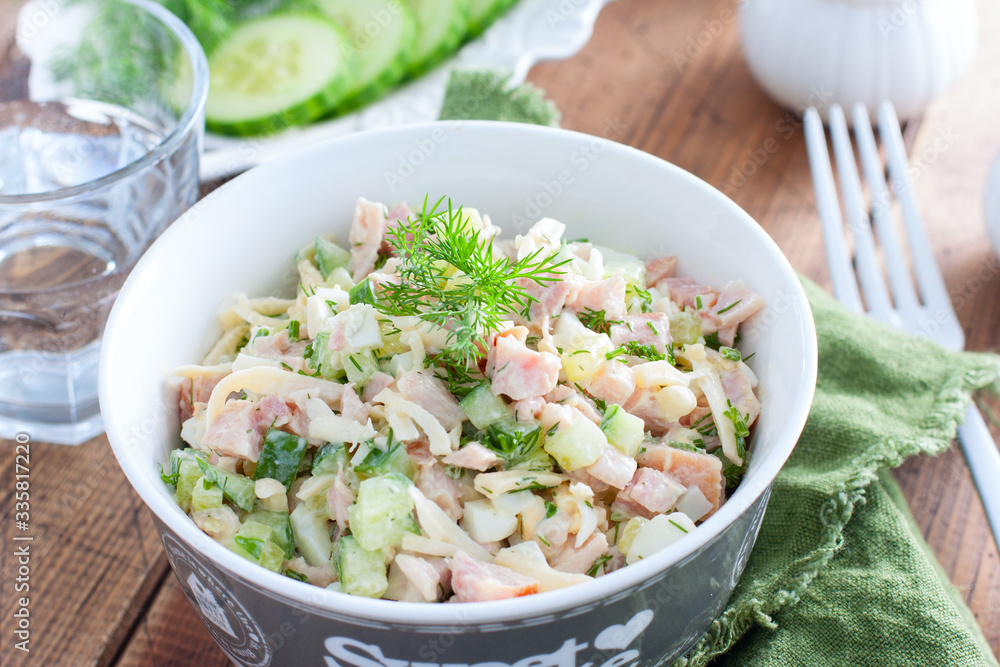 Smoked chicken salad with fresh cucumber in a white bowl, selective focus Smoked chicken salad with fresh cucumber in a white bowl, selective focus