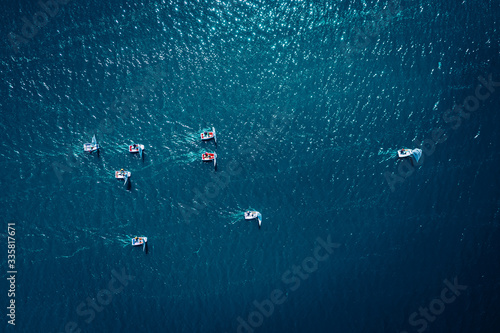 Regatta of small boats on the blue lake in summer