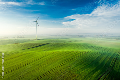 Wonderful wind turbine on green field, view from above