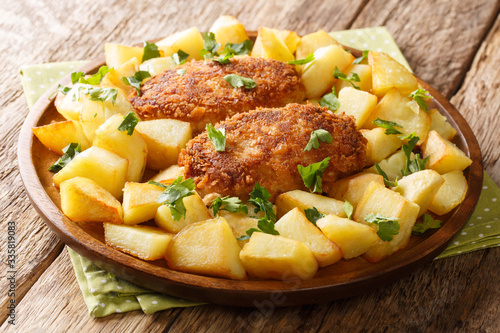 Dish of Russian cuisine Pozharsky chicken cutlets with fried potatoes close-up in a plate. horizontal photo