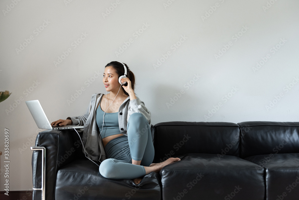 A young Asian woman using a computer in the living room