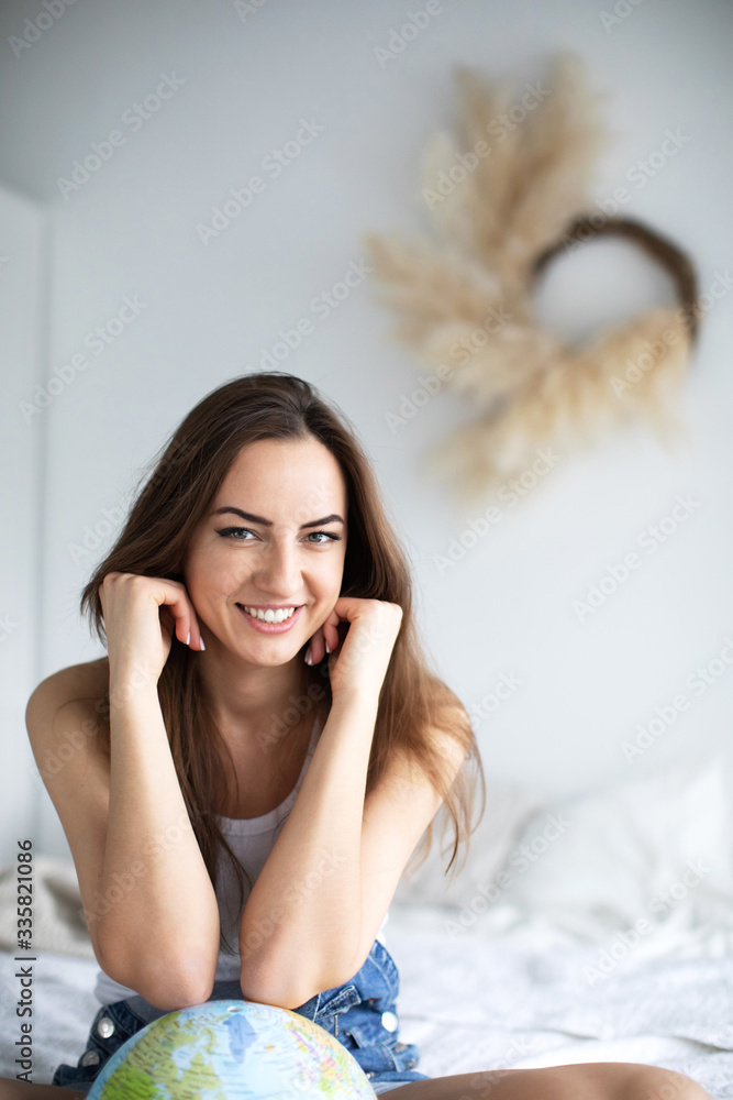 Young beautiful girl at home with a globe. Young beautiful girl at home with a globe.