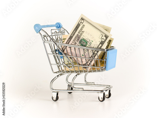 Dollars are in a small shopping cart. Finance savings concept.