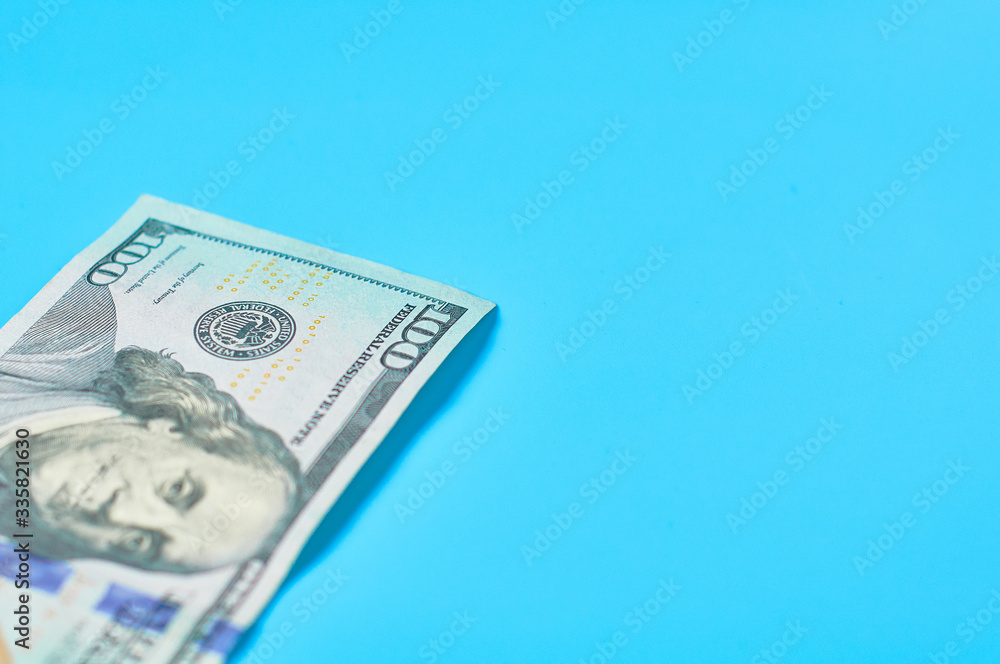 Banknote of one hundred dollars on blue background. Payment of pensions, salaries. Bank loan. Business concept Banknote of one hundred dollars on blue background. Payment of pensions, salaries. Bank loan. Business concept
