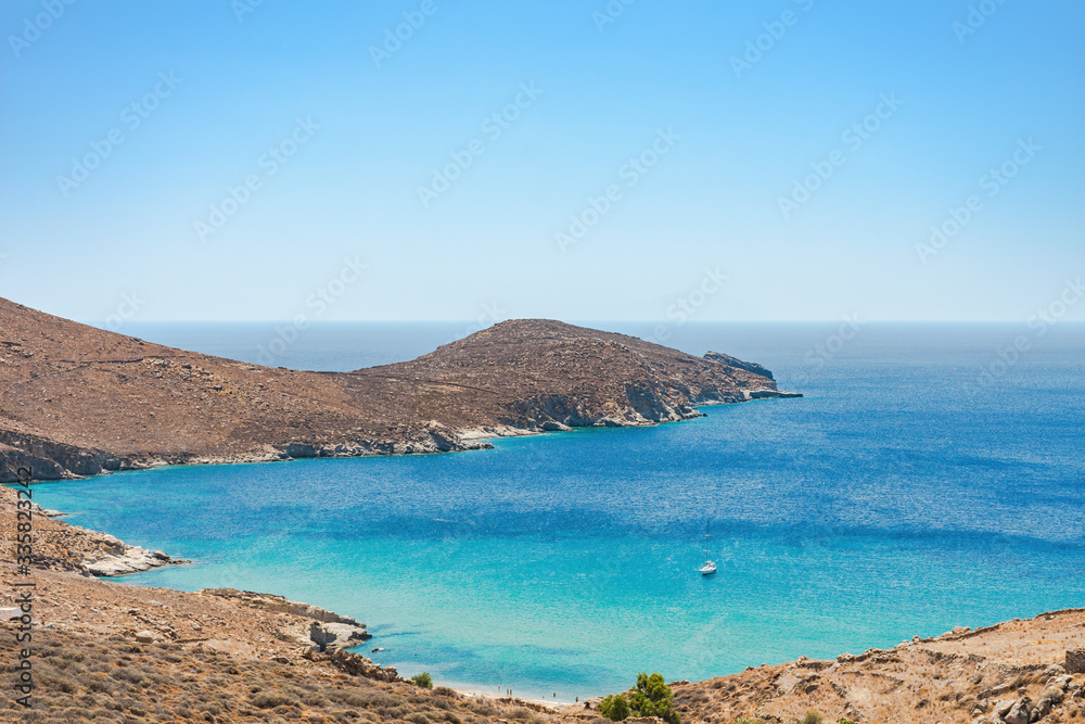 An isolated beach with turquoise water and a yacht in Serifos island Cyclades Aegean Greece on a sunny summer day An isolated beach with turquoise water and a yacht in Serifos island Cyclades Aegean Greece on a sunny summer day