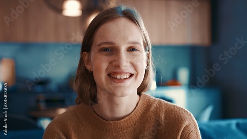 Konstfotografi Portrait of happy attractive girl with blonde hair in brown sweater loking to the camera and smiling
