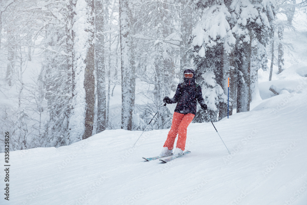 Young woman skiing under snowfall