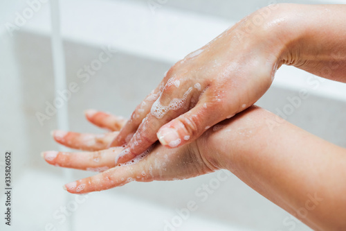 Close-up of woman rubbing hands with a soap.