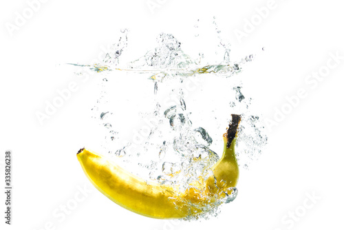 one banana falling into water on a white background with splashes