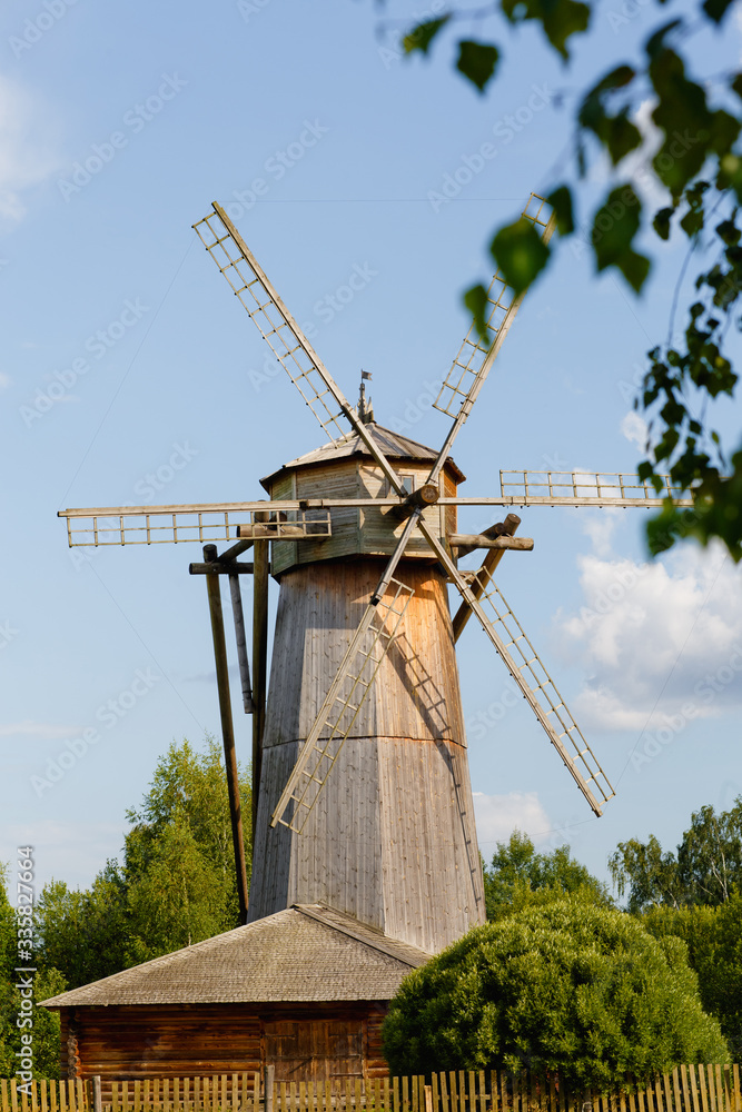 Traditional windmill wooden house on a green grass and under a clear blue sky Traditional windmill wooden house on a green grass and under a clear blue sky