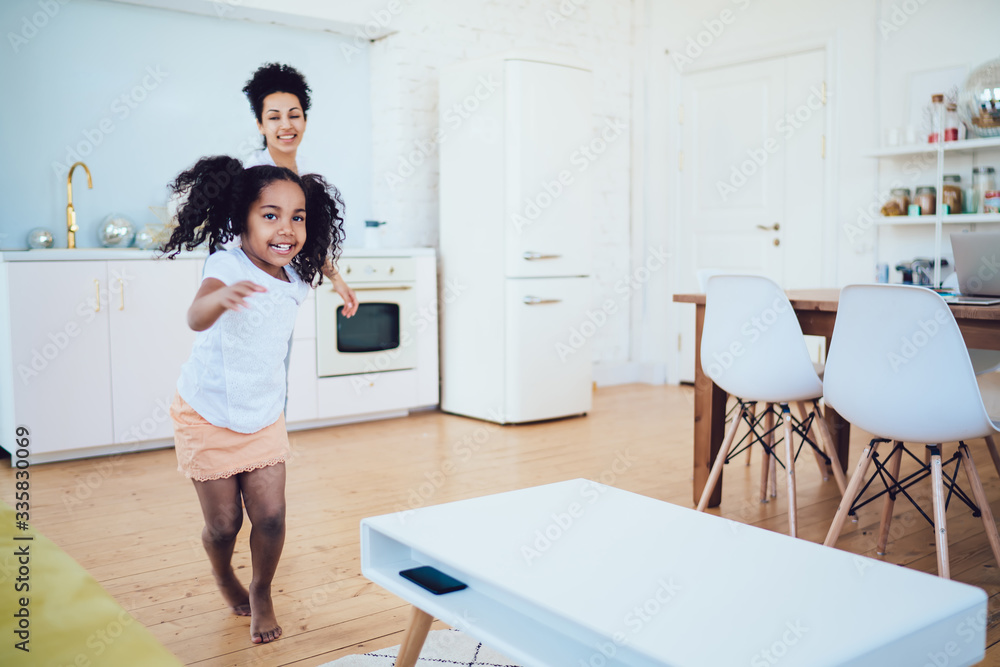 Cheerful black girl running and leading mother Cheerful black girl running and leading mother