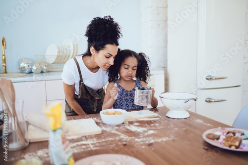 Loving woman with daughter cooking in kitchen