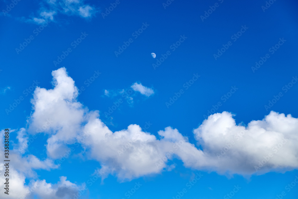 Blue sky background with white clouds and moon Blue sky background with white clouds and moon