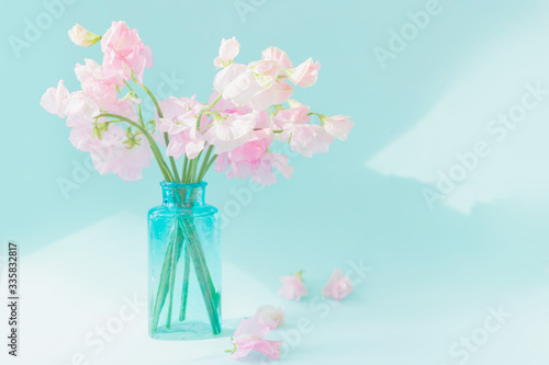 Wallpaper Mural Bouquet of soft pink sweet peas Lathyrus in beautiful transparent vase on blue background.Copy space.Spring concept.Postcard for International Women's Day on March 8, Valentine's Day,14 of February Torontodigital.ca