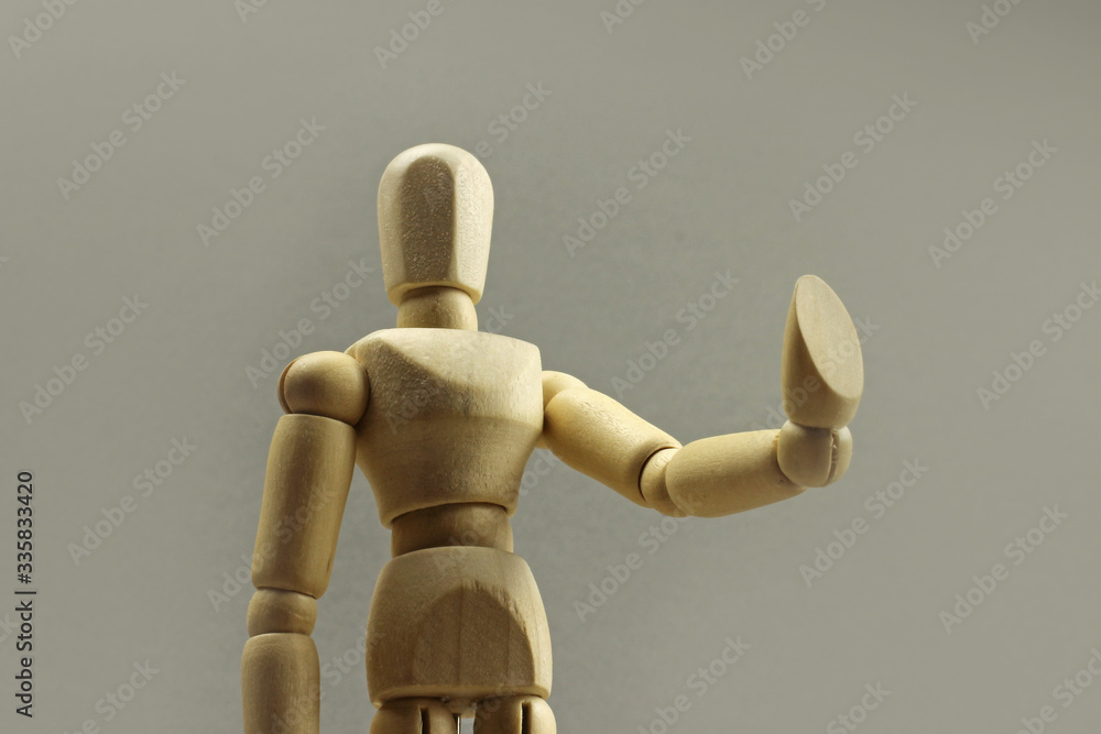 Wooden figure making stop sign on a gray background. Concept Wooden figure making stop sign on a gray background. Concept
