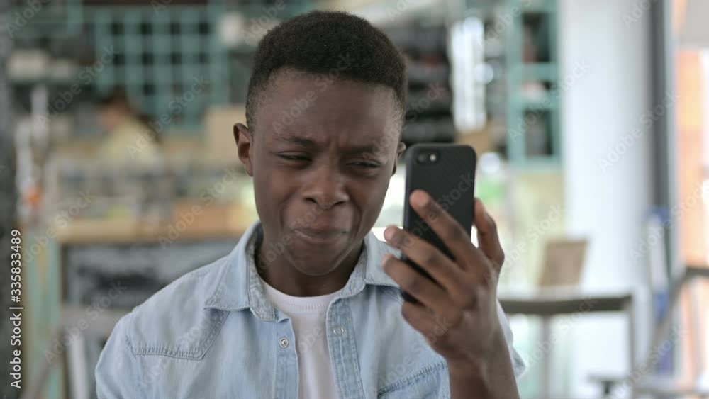 Portrait of Young African Man reacting to Failure on Smartphone Portrait of Young African Man reacting to Failure on Smartphone