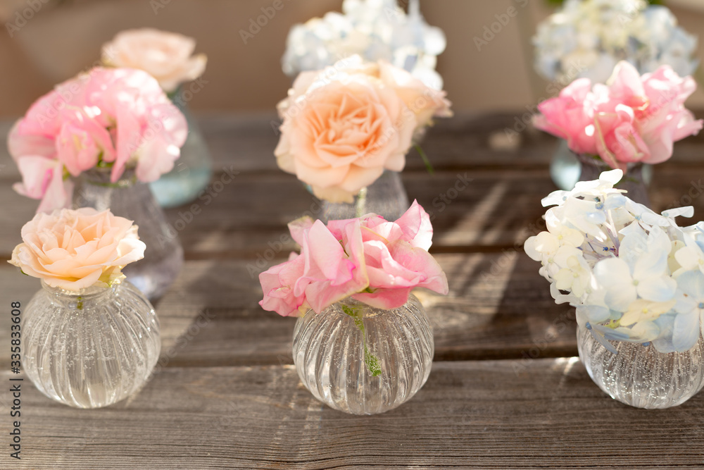 Decoration of blooming blue hydrangea, sweet pea Lathyrus, bush roses in small crystal vases on wooden background. Design,creative.International Women's Day,March 8 and Valentine's Day,14 of February Decoration of blooming blue hydrangea, sweet pea Lathyrus, bush roses in small crystal vases on wooden background. Design,creative.International Women's Day,March 8 and Valentine's Day,14 of February