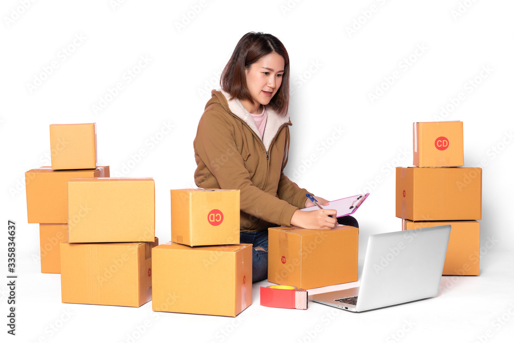 Asian women wear yellow robes. Review orders from customers on laptops and mobile phones. On an isolated white background Online business and delivery concepts Asian women wear yellow robes. Review orders from customers on laptops and mobile phones. On an isolated white background Online business and delivery concepts