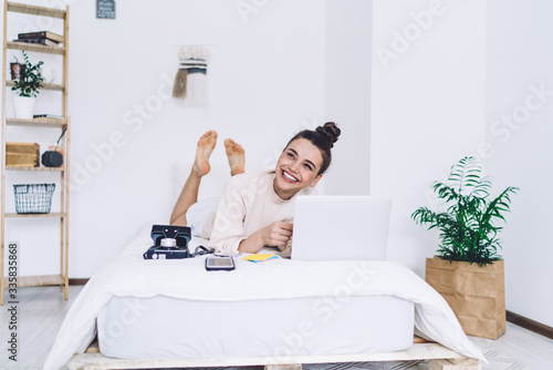 Smiling woman photographer chilling out with laptop at home