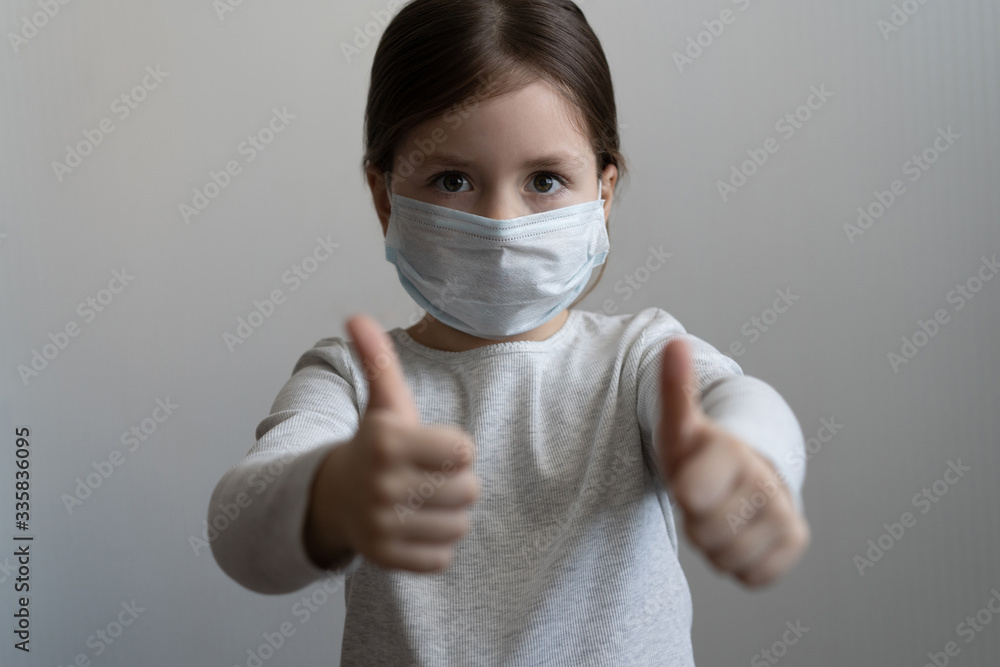 Little girl wearing mask for protect and thumb up gesture for stop corona virus outbreak. Little girl wearing mask for protect and thumb up gesture for stop corona virus outbreak.