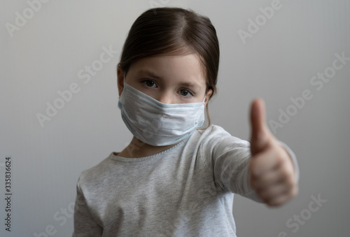 Little girl wearing mask for protect and thumb up gesture for stop corona virus outbreak.
