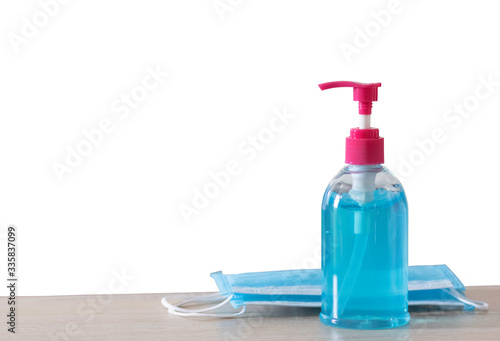 The blue alcohol gel bottle is placed on the right side with the mask. On the table and the white wall Alcohol Hand washing Anti-virus and anti-virus Covid-19 Copy space