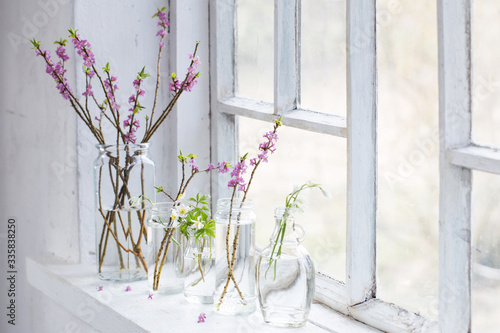 spring flowers in jars on old white windowsill
