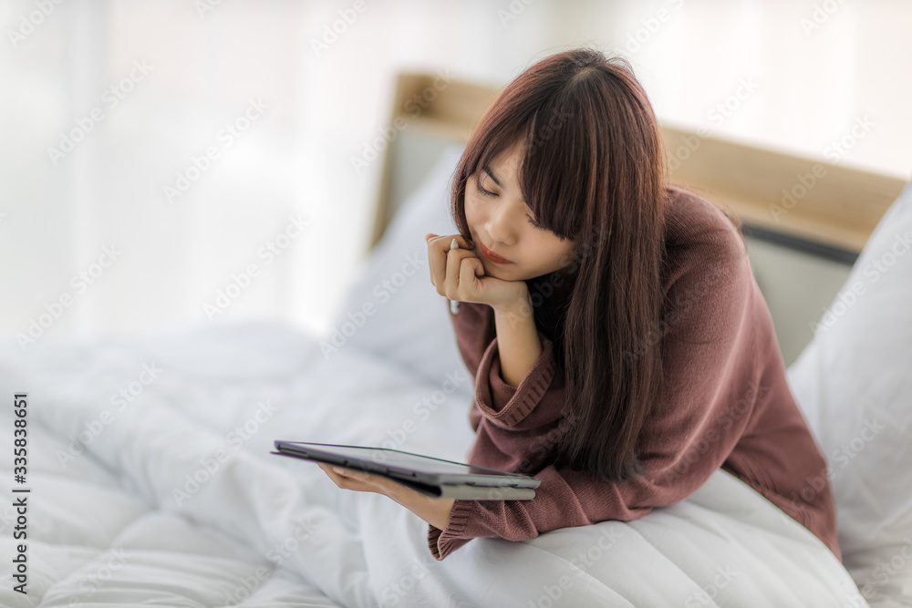 Asian woman using tablet for working, educational, e-commerce, social media in her bed. corovavirus covid-19, stay at home, work form home concept. Asian woman using tablet for working, educational, e-commerce, social media in her bed. corovavirus covid-19, stay at home, work form home concept.