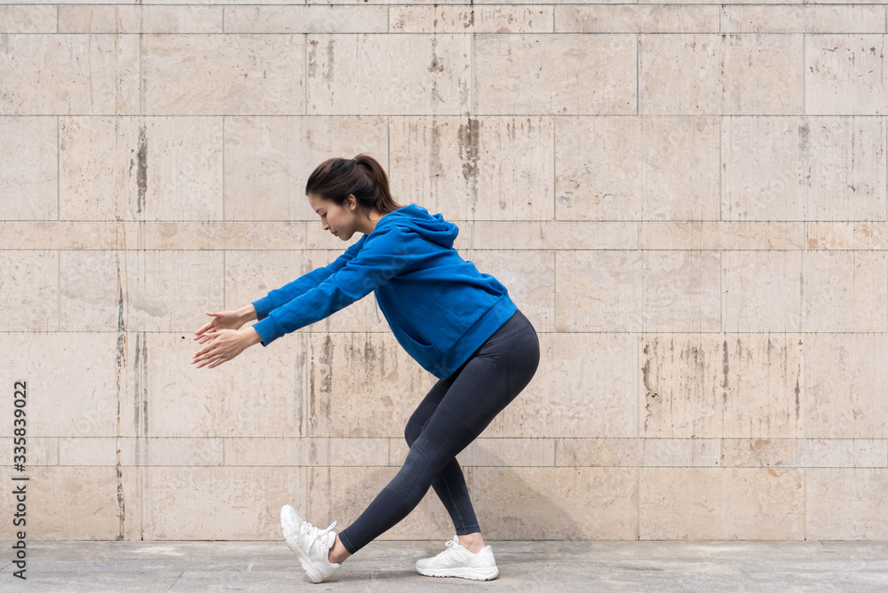 Fototapeta premium A young Asian woman is doing warm-up exercises