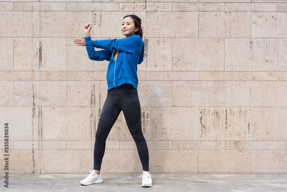 Fototapeta premium A young Asian woman is doing warm-up exercises
