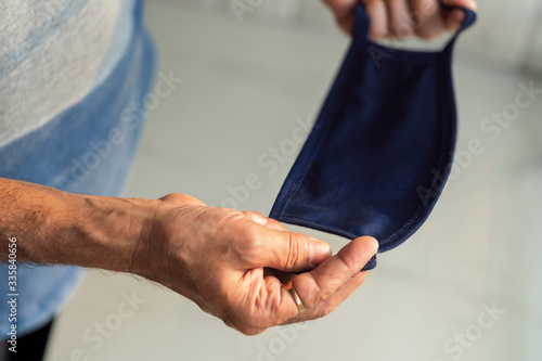 Man Hand Holding protective mask. Person hand holding medical mask for protection against flu  disease  novel coronavirus  covid 19 . Background for Corona Virus  staying at home  social awareness.