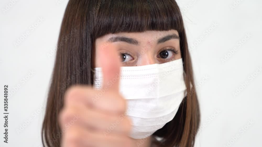 An asian young girl that infected from coronavirus makes positive sign as treatment. An asian young girl that infected from coronavirus makes positive sign as treatment.