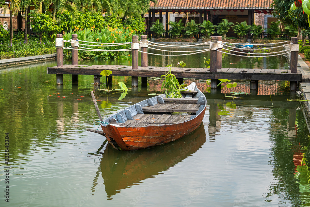 Small wooden boat on the Lang Co Bay, where you can see the bridge on Ah1 Road across the Lang Co Bay to the Hai Van Tunnel, connect Hue and Danang Vietnam.