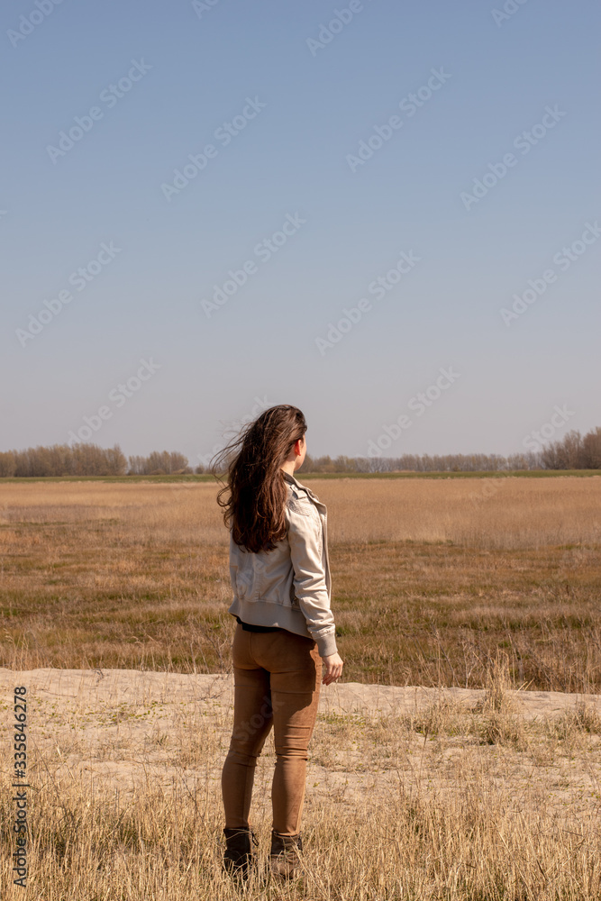 Beautiful young woman looks into the distance in nice weather Beautiful young woman looks into the distance in nice weather