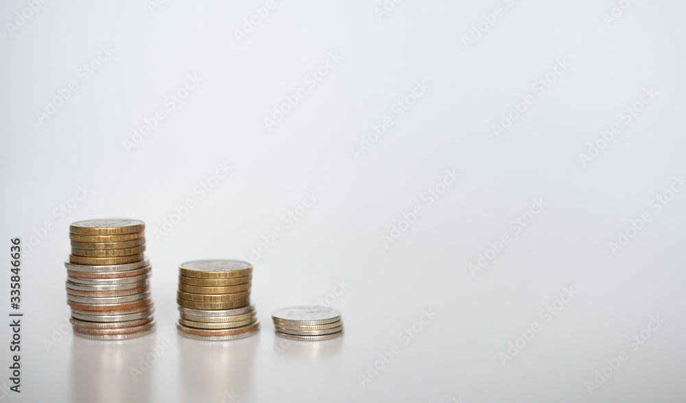 Three stacks of coins of different heights on a gray background: banner, text space, financial concept, Bank and loans Three stacks of coins of different heights on a gray background: banner, text space, financial concept, Bank and loans