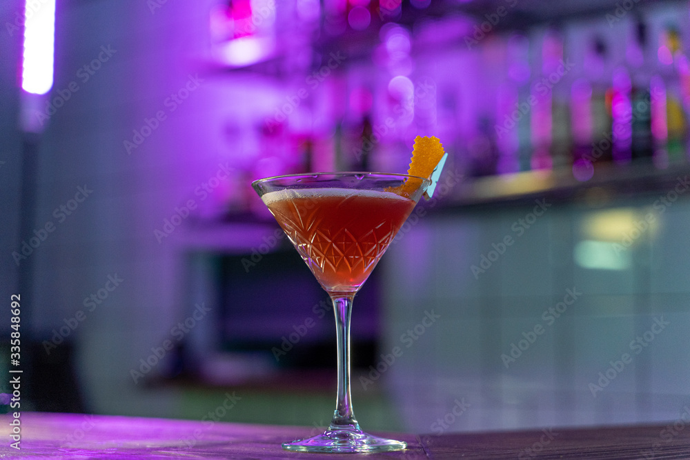 Cosmopolitan cocktail on wooden table in a pink neon light of a loft bar Cosmopolitan cocktail on wooden table in a pink neon light of a loft bar