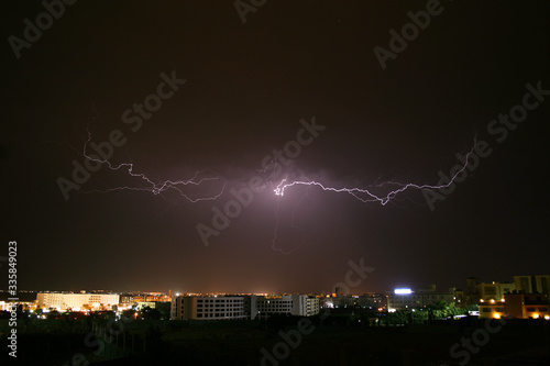Bolt of lightening seen at night over a town
